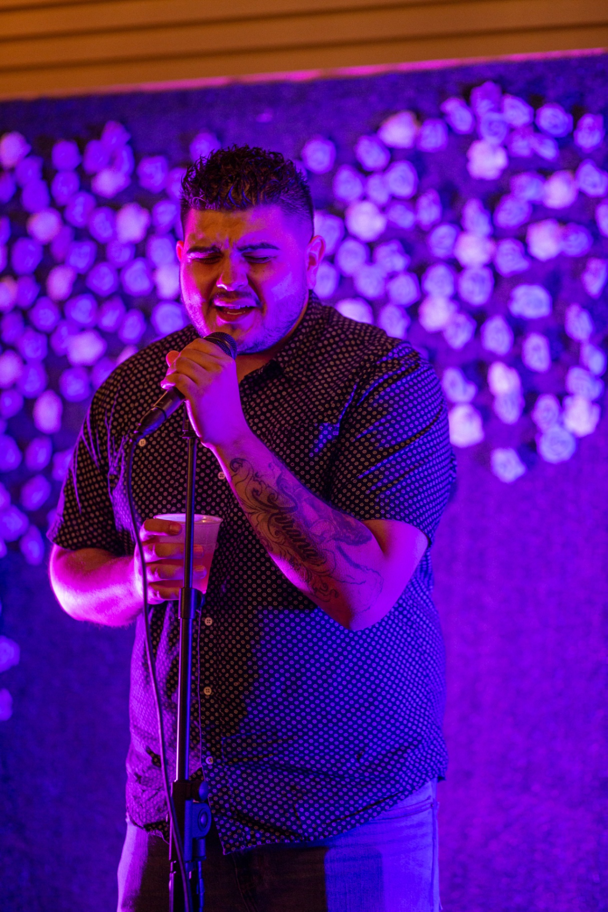 Vocalist with cup in hand at Hues Cookout 2022