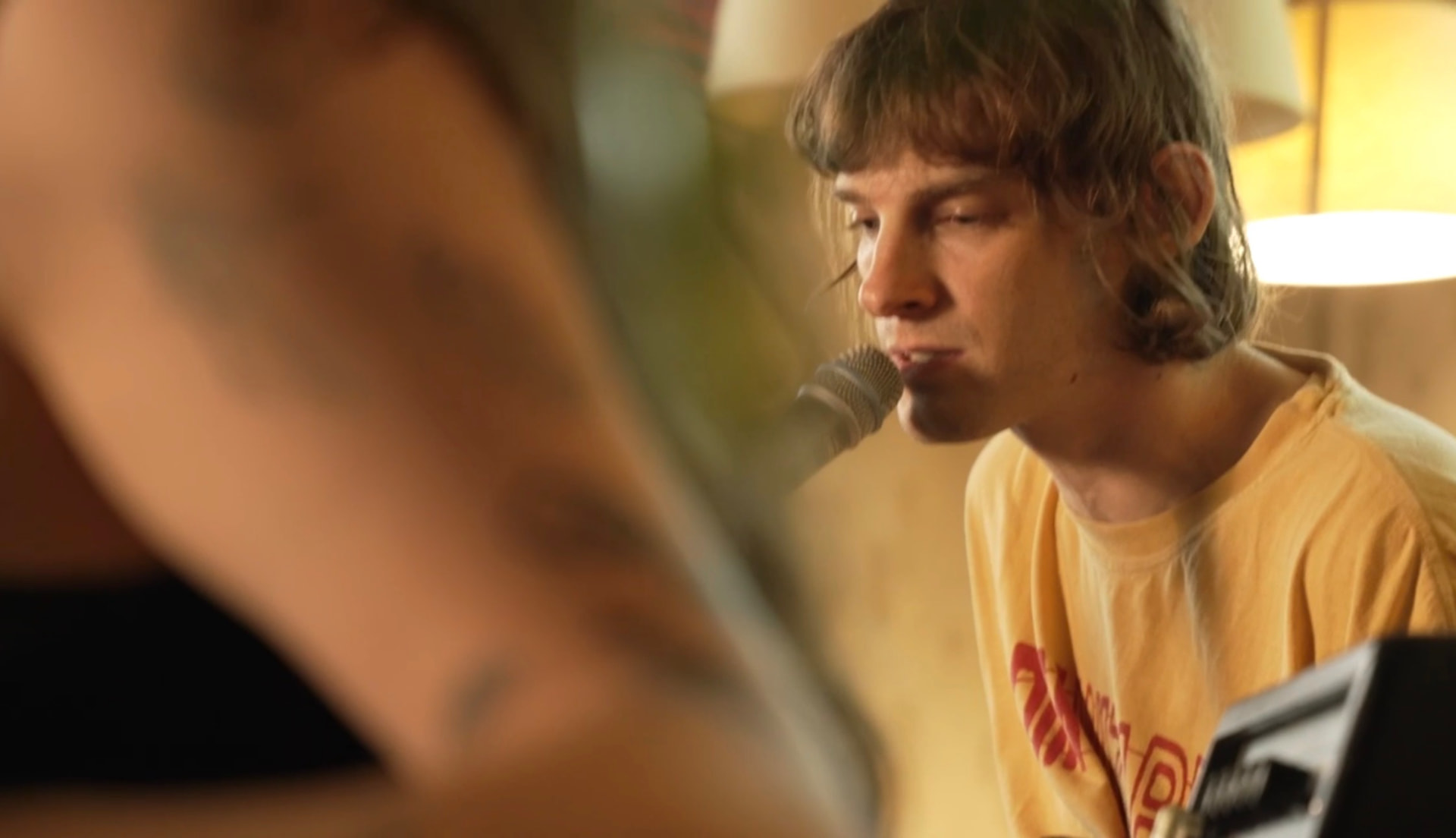 Musician performing into a microphone in an intimate indoor setting